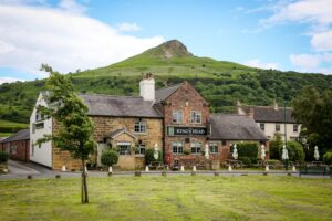 The Inn Collection Group logo with a dog-friendly pub with rooms in the background