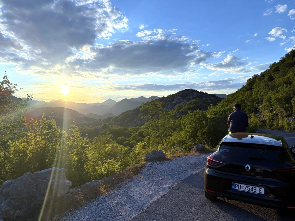 Driving in Montenegro: sunset over the Lake Skadar mountains from a roadside viewpoint