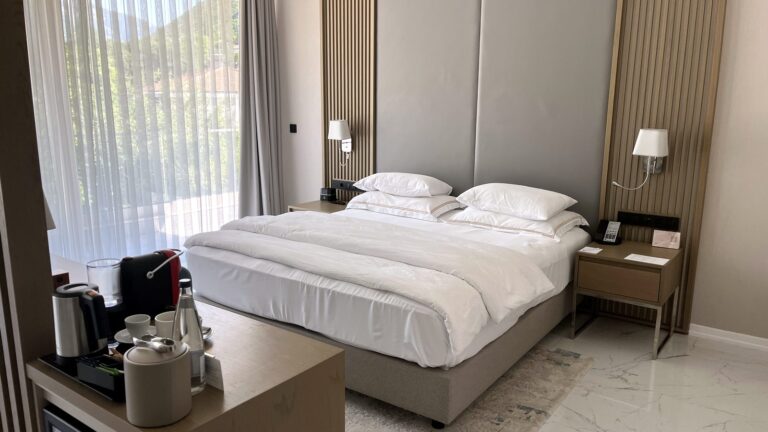 King-size bed in Hyatt Regency Kotor Bay Resort room with Nespresso machine and patio doors