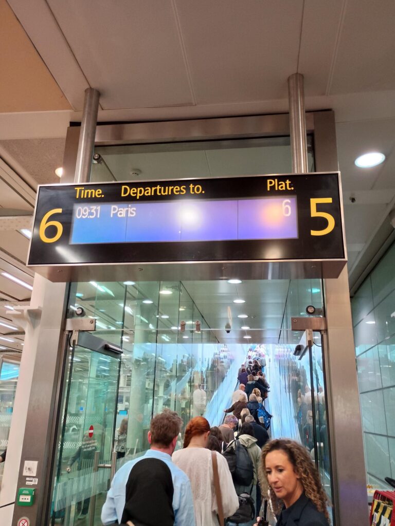 Passengers boarding Eurostar 09:31 Paris train at St Pancras International platform 5 gate sign