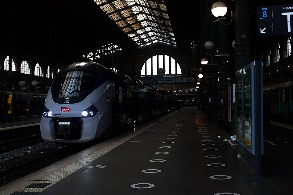 SNCF train at Paris Gare du Nord platform under iron and glass canopy roof