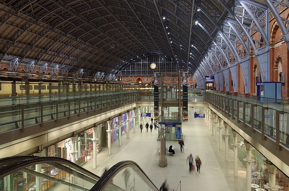 St Pancras International station concourse interior at night with arched trainshed roof escalators