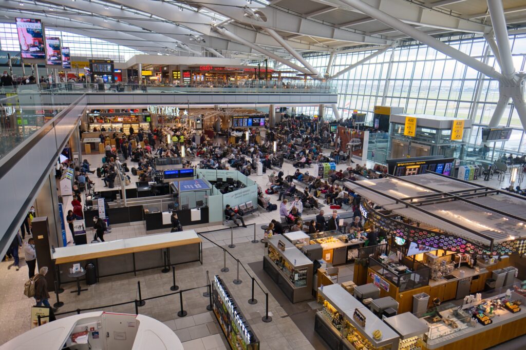 Busy departures area at Heathrow Terminal 5 with passengers waiting near gates