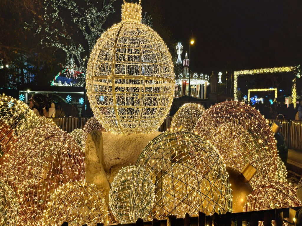 Giant illuminated golden baubles at the Vienna Christkindlmarkt at night