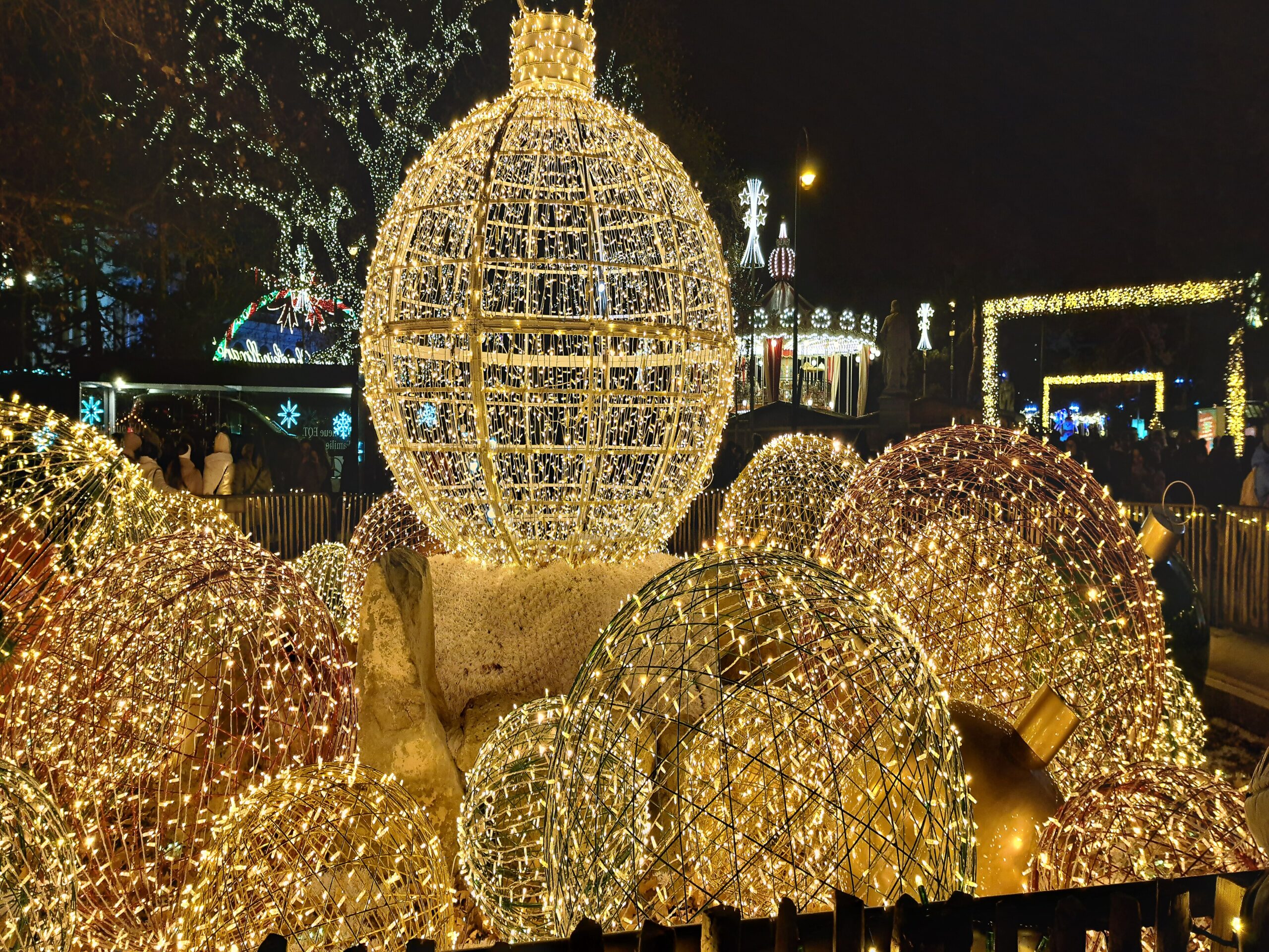 Giant illuminated golden baubles at the Vienna Christkindlmarkt at night