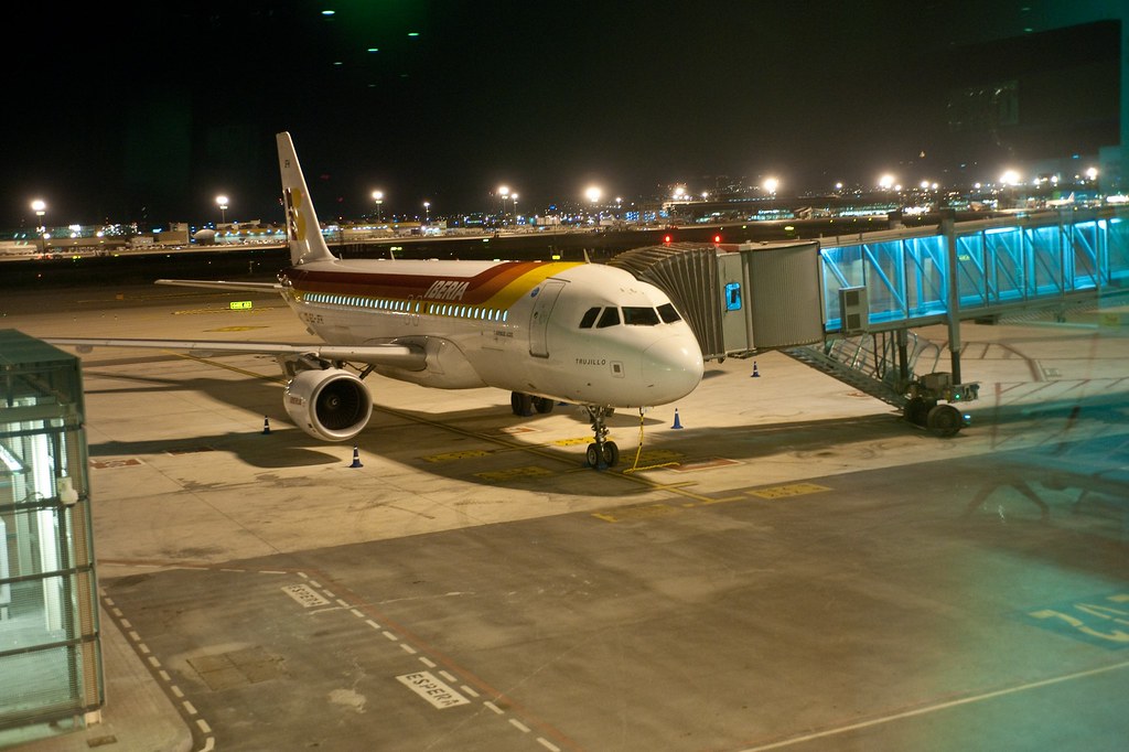 Iberia Airbus A320 parked at a Terminal 1 gate at Barcelona El Prat at night