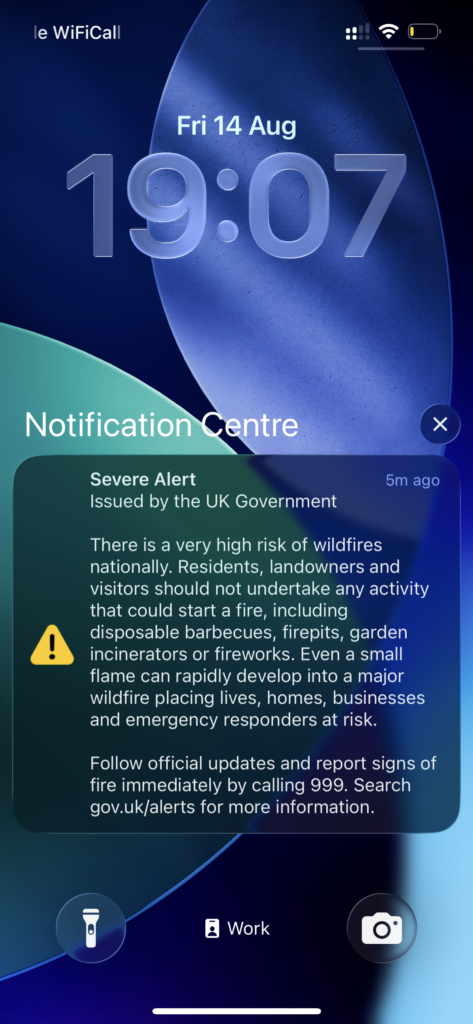 iPhone lock screen showing the UK government severe wildfire alert in English