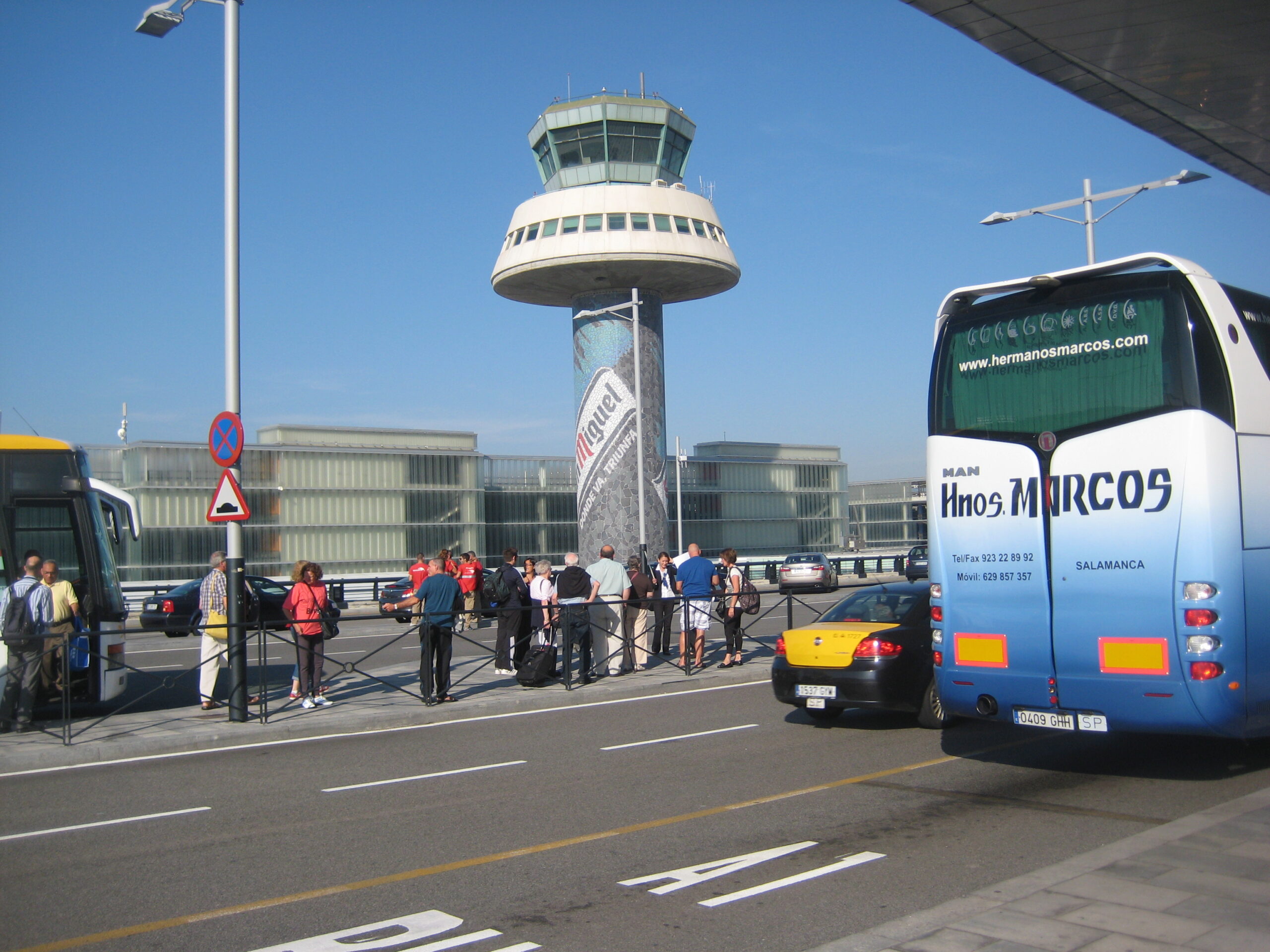 Passengers moving through the airy departures concourse at Barcelona El Prat Terminal 1