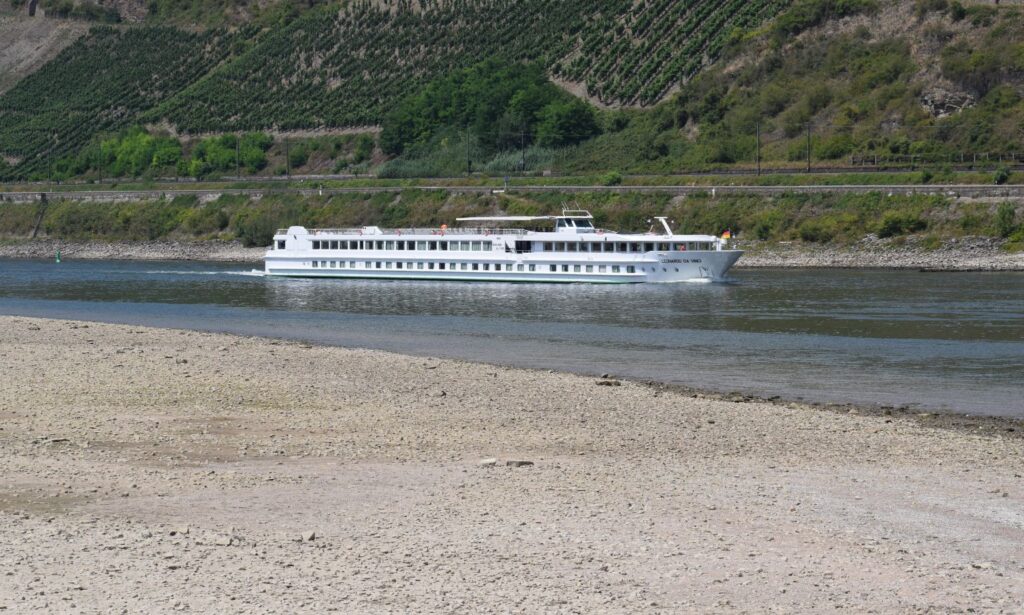 River cruise ship passing huge exposed sandbanks at Osterspai on the Rhine