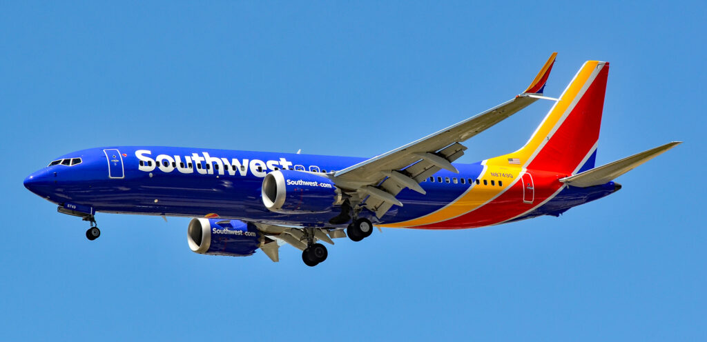 Southwest Boeing 737 MAX 8 on approach with landing gear down against a blue sky