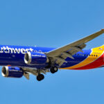 Southwest Boeing 737 MAX 8 on approach with landing gear down against a blue sky