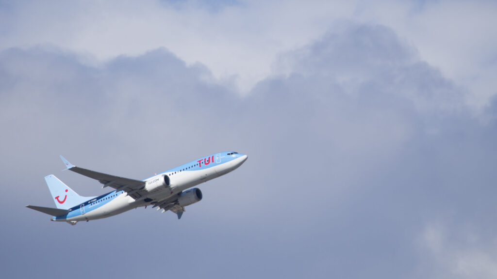 TUI Boeing 737 MAX 8 climbing after takeoff against a cloudy sky