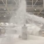 Virgin Atlantic foam at Heathrow: jet buried under foam inside a hangar at night