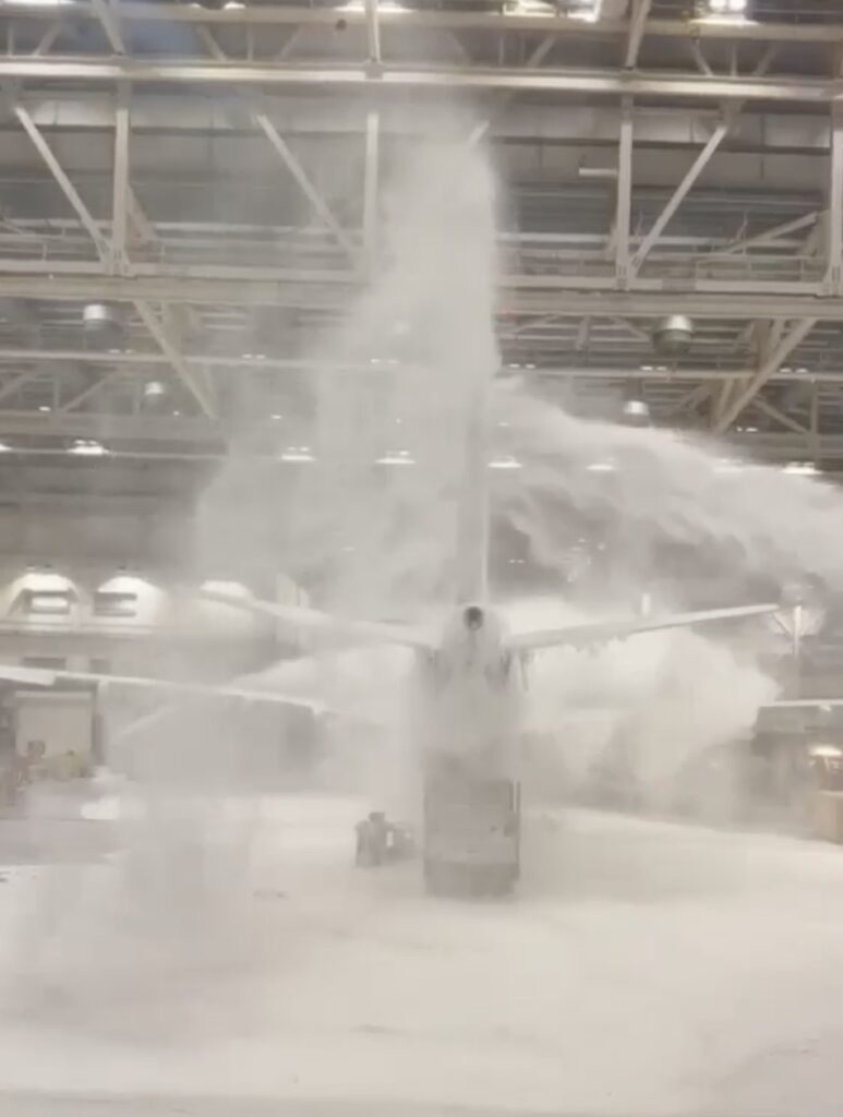 Virgin Atlantic foam at Heathrow: jet buried under foam inside a hangar at night