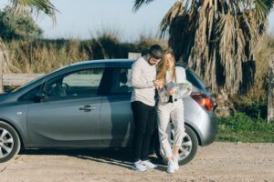 Couple checking a travel itinerary on a beach with suitcases, representing Cedar Tree Travel Insurance cover